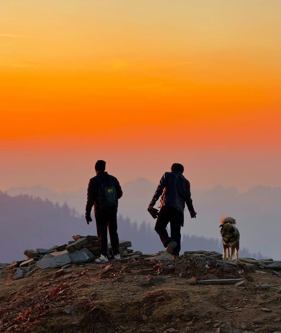 Trekkers watching the sunset from a ridge in Kashmir