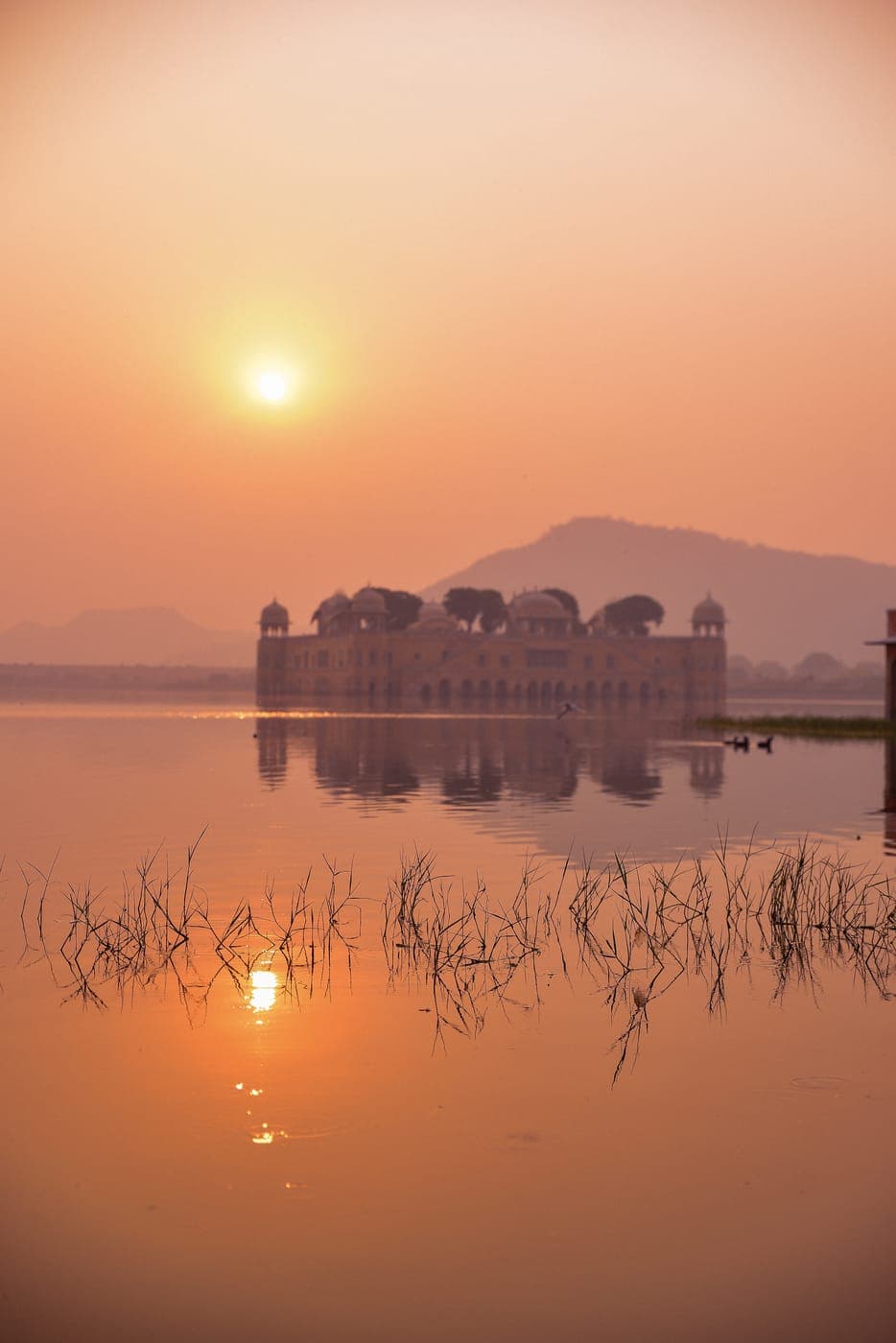Jal Mahal palace on a lake at sunset in Jaipur